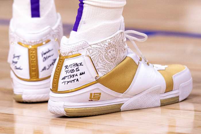 View of white and gold Nike LeBron shoes.